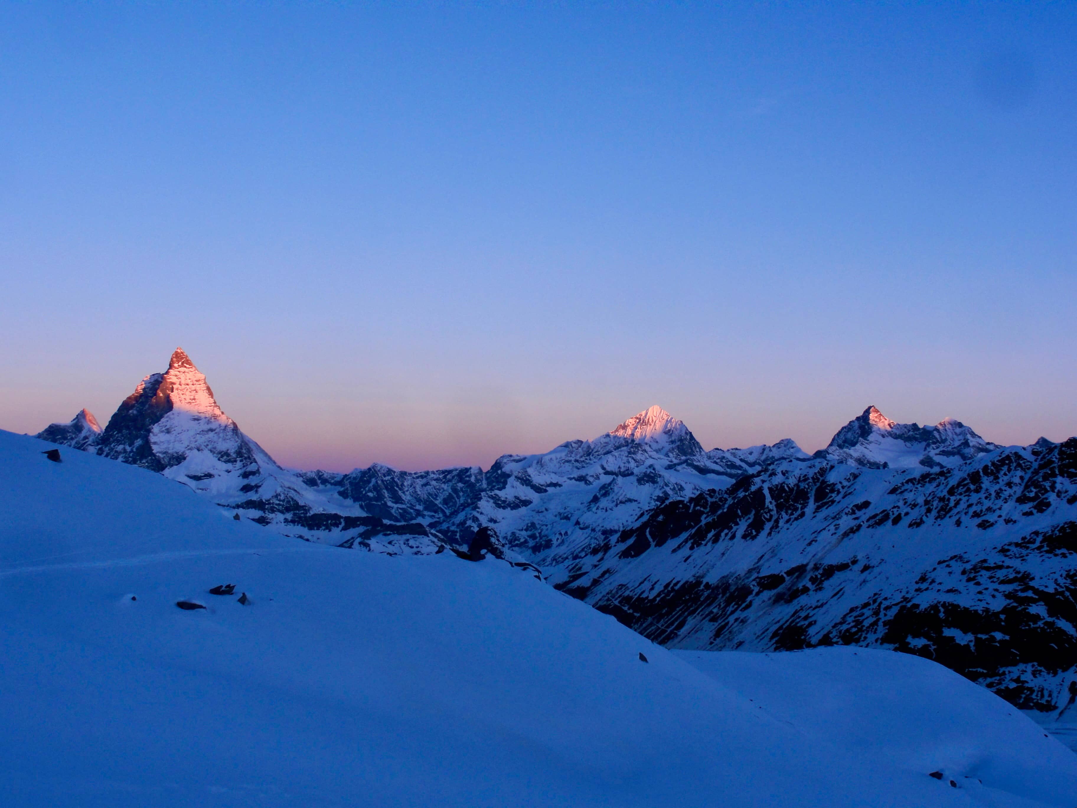 Die ersten Sonnenstrahlen erhellen die Berggipfel