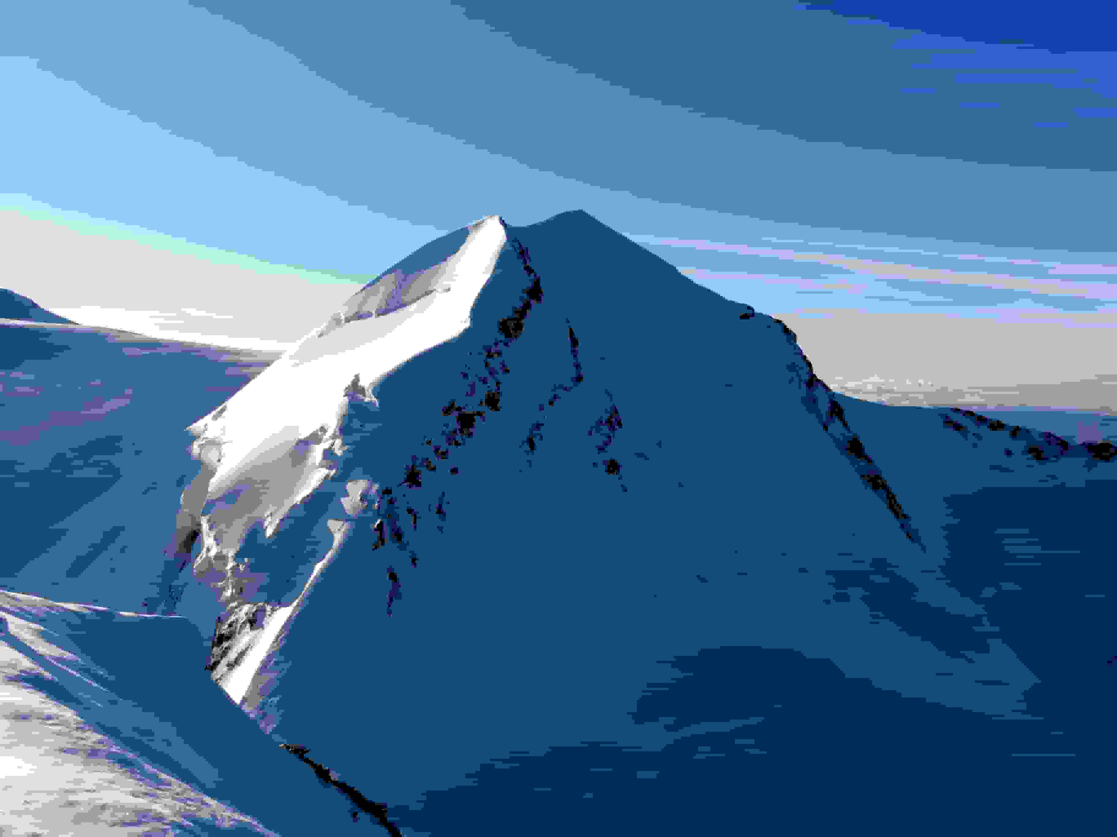 Der schneeweisse Castor vom Pollux aus gesehen. Der Aufstieg erfolgt über die schattige Westflanke (eine Seilschaft am Einstieg ist zu erkennen)